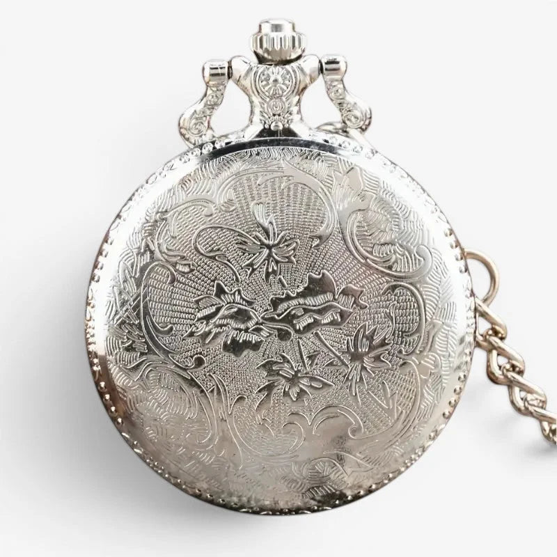 Silver compass pocket watch with intricate floral engravings and decorative crown on top in silver metal