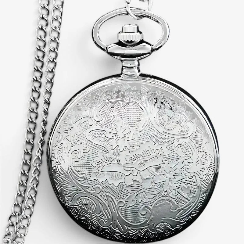 Silver dragon pocket watch with intricate floral engraving on its circular face and matching silver chain