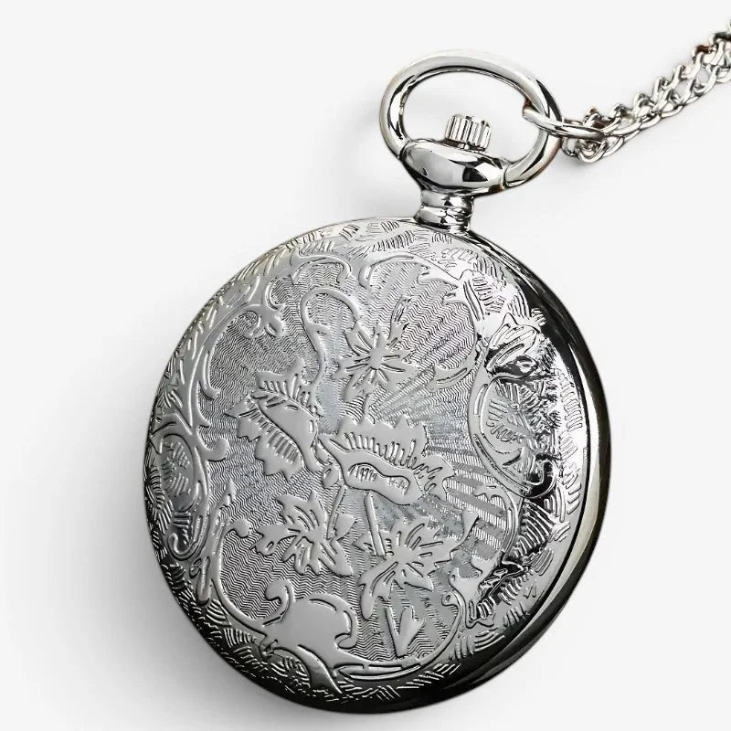 Silver open compass pocket watch with intricate floral and scrollwork engraving on circular face and matching chain