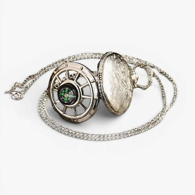 Silver-toned pocket watch with compass face and ornate engraved lid attached to matching chain for stylish use