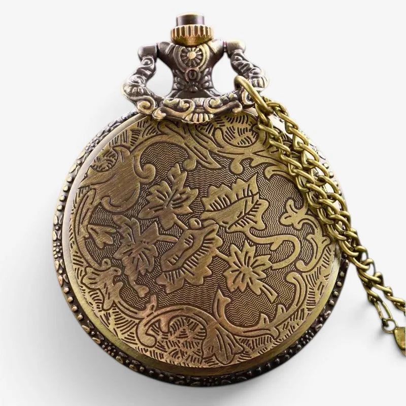 Antique brass skull pocket watch with intricate floral engraving and decorative gear-like clasp visible on back side