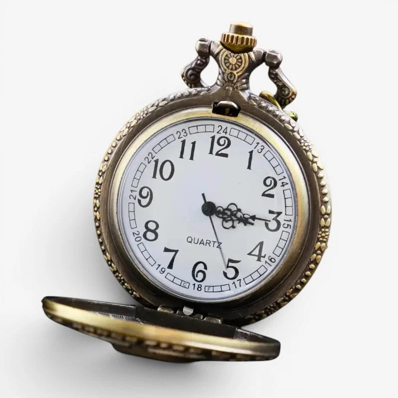 Antique-style brass skull pocket watch with white face black numerals and hands and ornate casing detailing