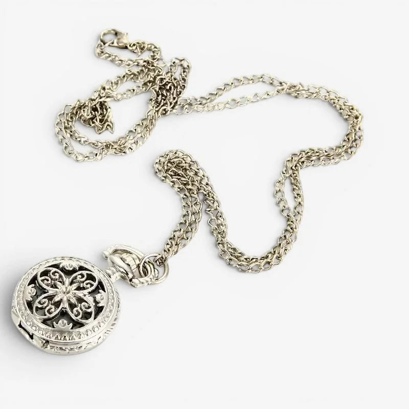 Small antique pocket watch with silver filigree pendant featuring intricate floral design and matching chain