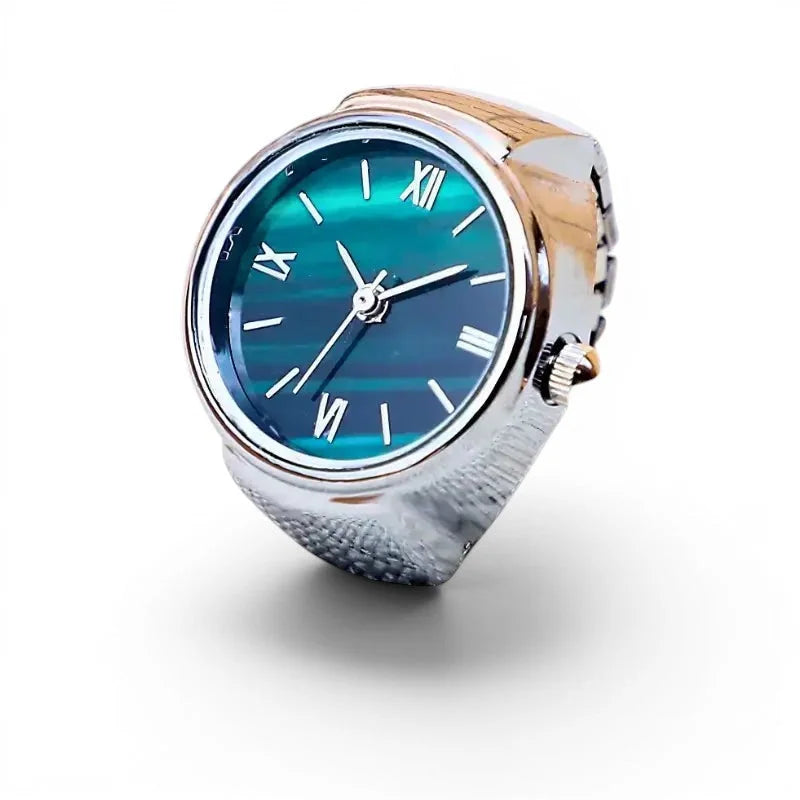 A small ring watch with a gradient teal dial roman numerals and a two-tone silver and rose gold metallic band