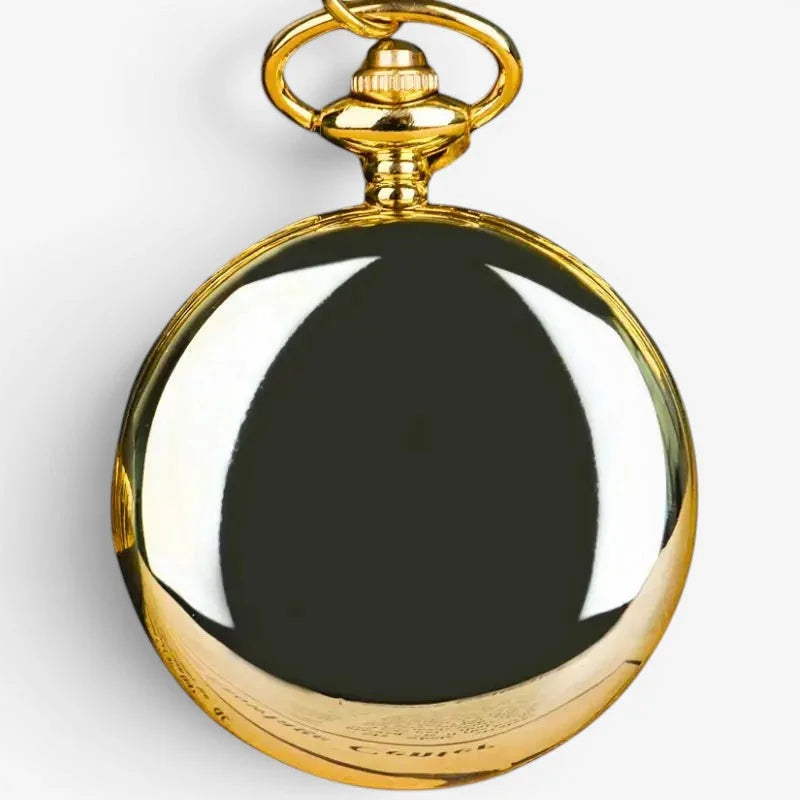 A polished gold-toned smooth quartz pocket watch with a reflective black face and ornate winding crown