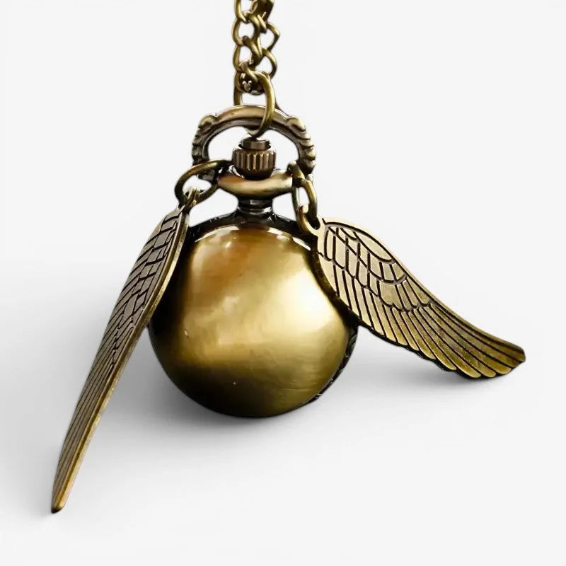Antique brass-colored snitch ball pocket watch with ornate winged design and matching chain for vintage style use