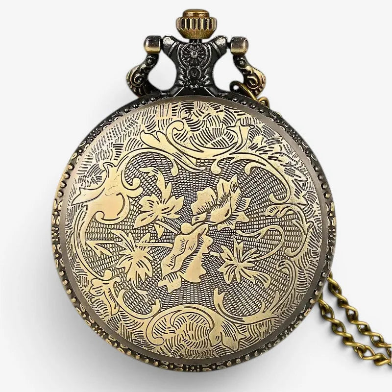 Antique-style brass spine pocket watch with intricate floral engravings and decorative crown visible from the front