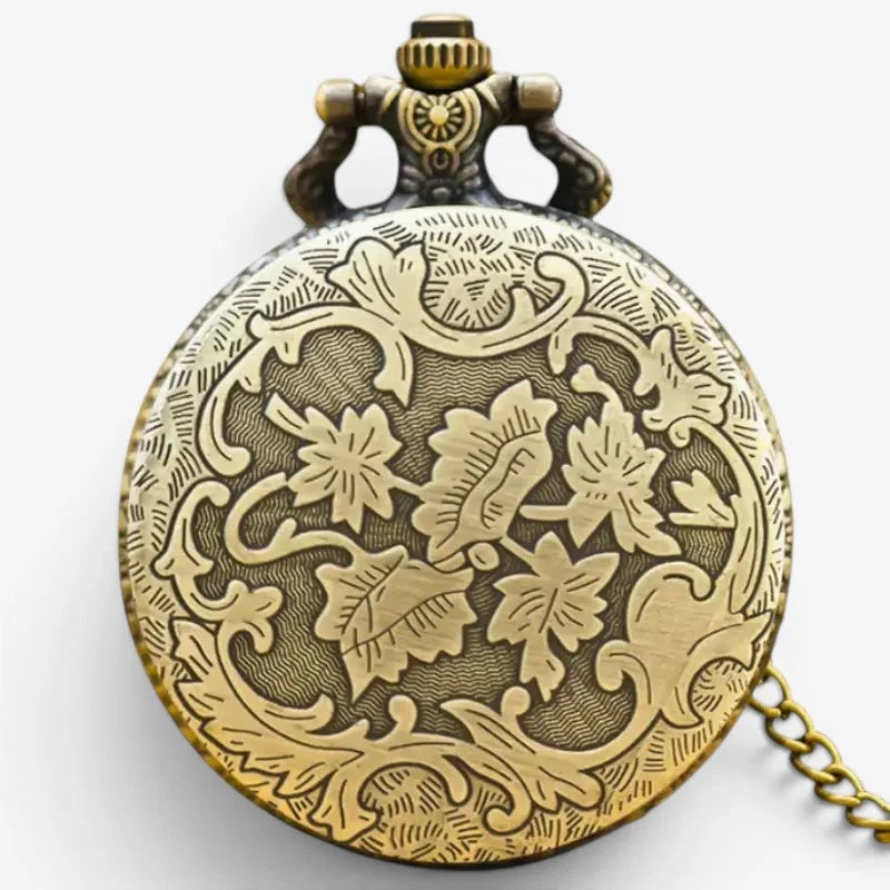 Antique brass swiss pocket watch with intricate floral engravings and decorative crown visible on front side