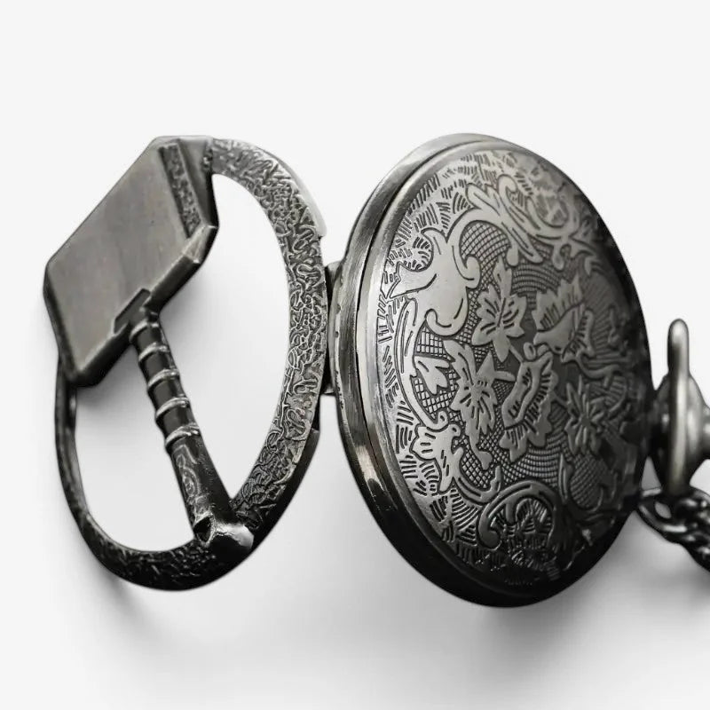 Antique-style silver-toned Thor pocket watch with intricate floral engraving and a hammer-shaped clasp on its face
