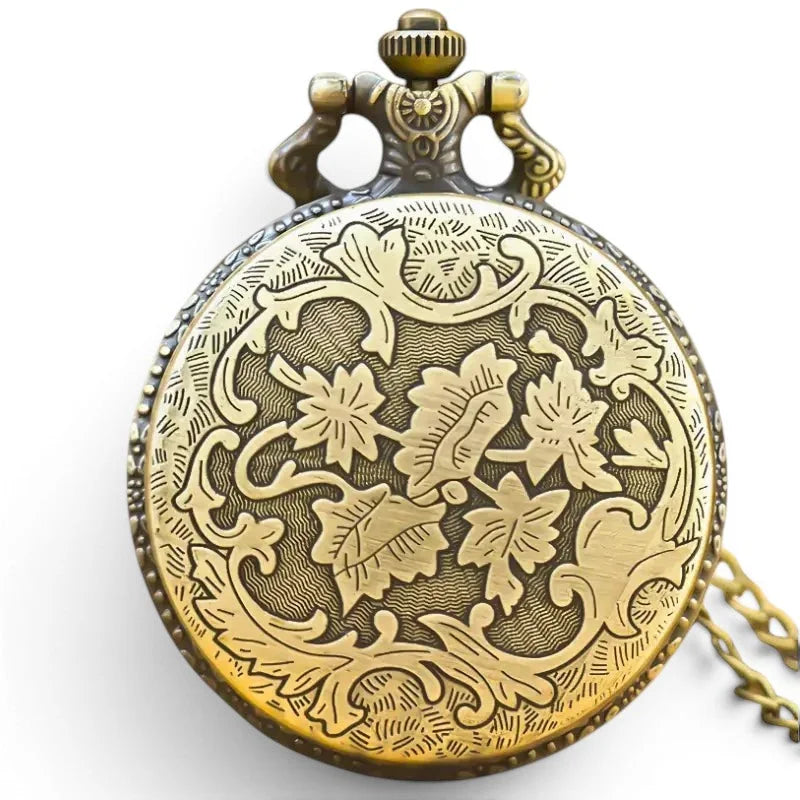 Antique brass train pocket watch with intricate floral engraving and decorative crown on the front side
