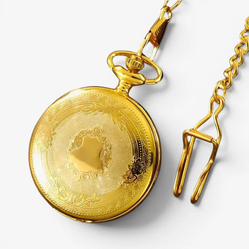 Vintage gold pocket watch with intricate floral and scrollwork engravings on polished brass face and matching gold chain
