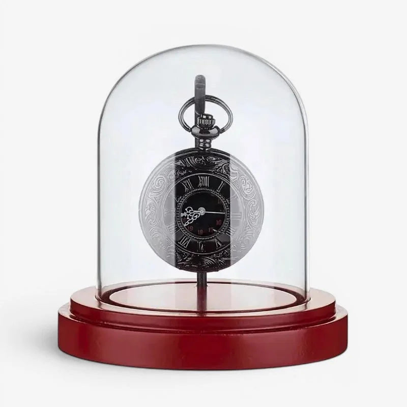 Vintage pocket watch stand featuring an ornate black pocket watch with silver roman numerals under glass dome on red wood base