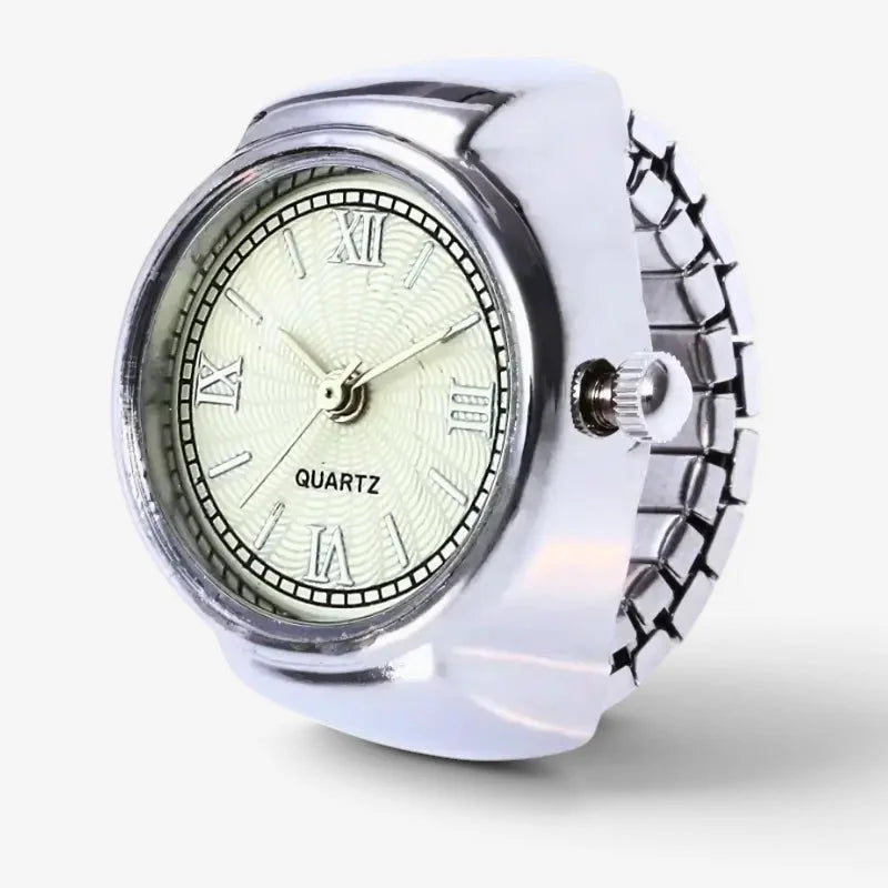 Vintage silver ring watch with silver-toned round face, roman numerals, quartz label, and geometric metallic band