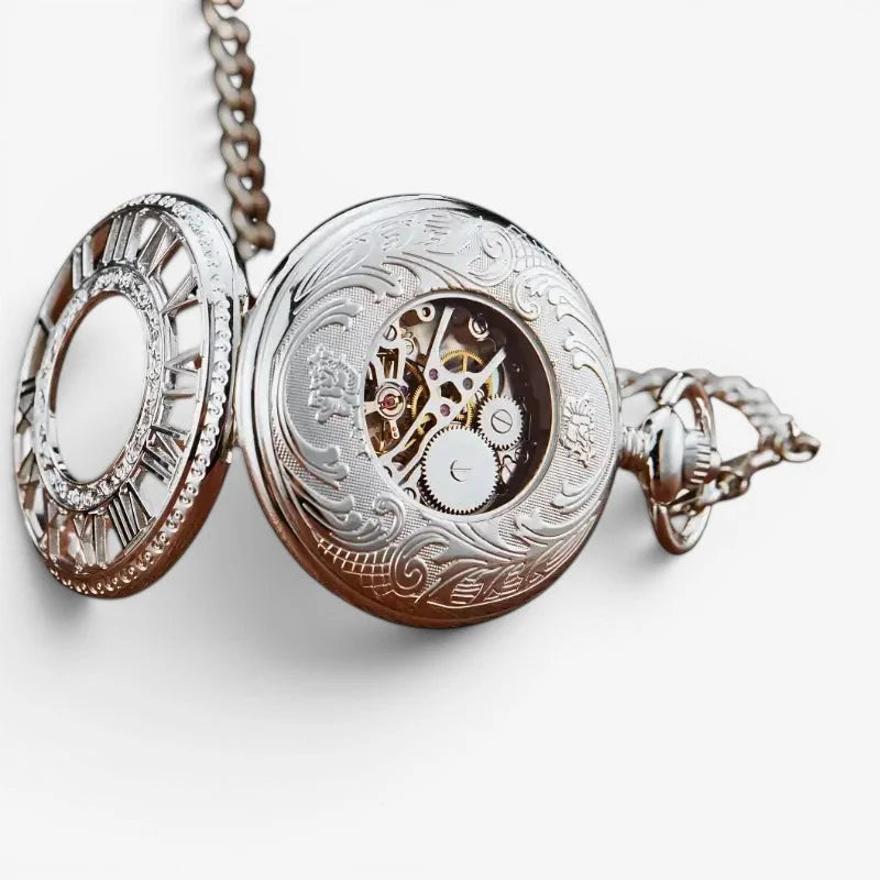 Silver ornate visible mechanism pocket watch with intricate engravings and mechanical movement attached to chain