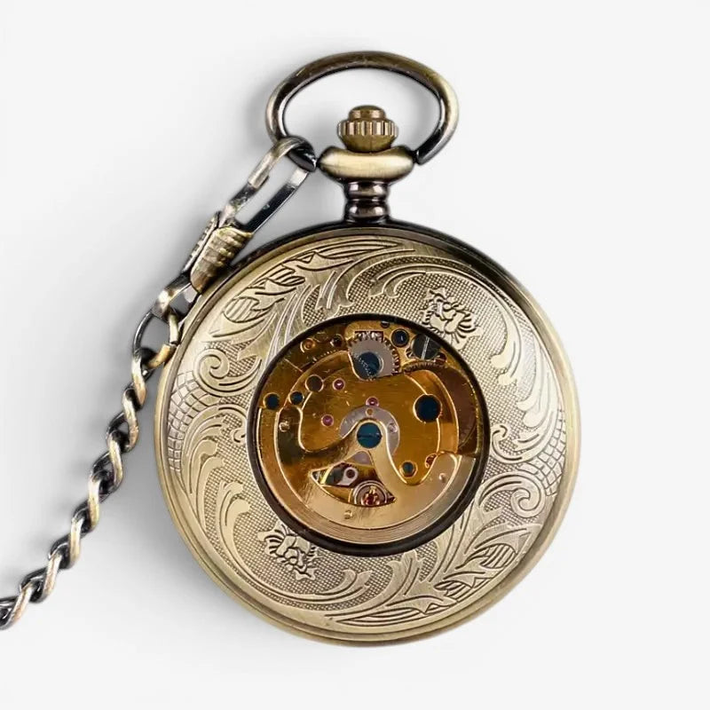 Antique brass western pocket watch with intricate floral engravings and visible mechanical movement