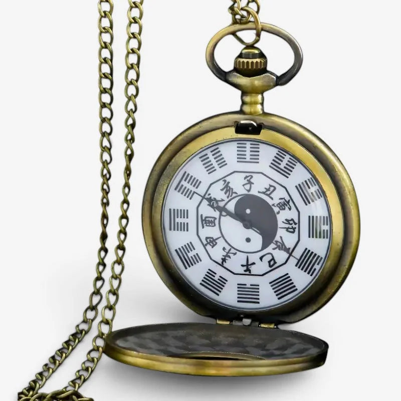 Antique brass-finished yin yang pocket watch with white face featuring black yin yang and i ching trigrams on ornate chain